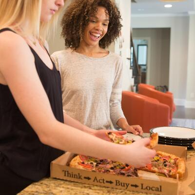 Customers grabbing pizza from the box
