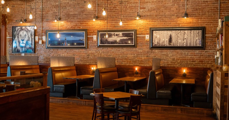 Cozy interior - exposed brick walls, leather booths, framed artwork.