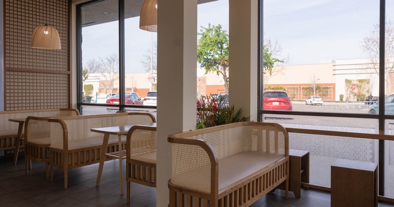 Interior, dining area, wooden tables with benches, large shop window, chandeliers