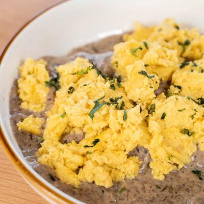 Scrambled eggs served over a creamy mushroom sauce or gravy.
