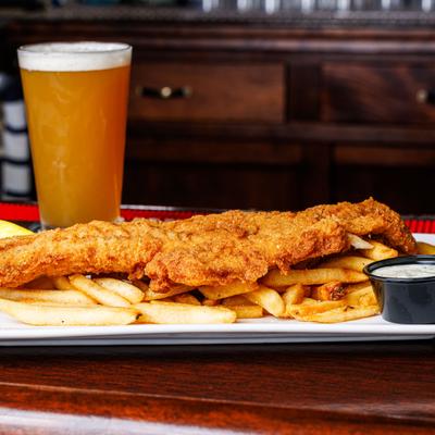 Breaded and fried haddock with beer on the bar counter.