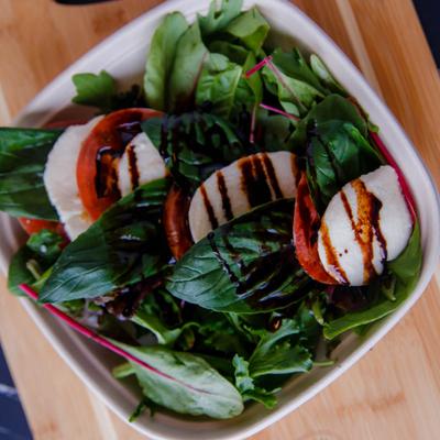 Caprese salad with mozzarella, tomatoes, basil, organic mixed greens and balsamic reduction
