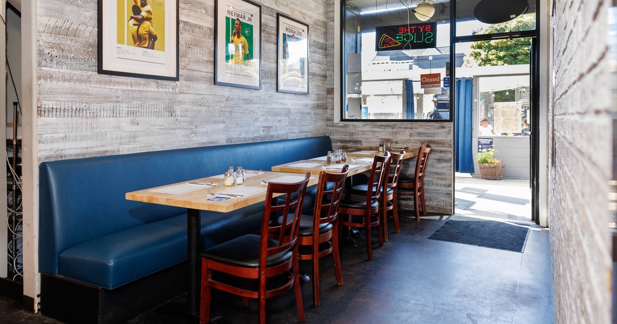 Restaurant seating area with blue booth and soccer posters