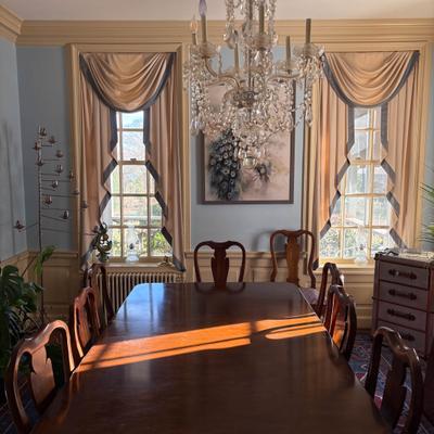 Traditional dining room with a long wooden table and a crystal chandelier.