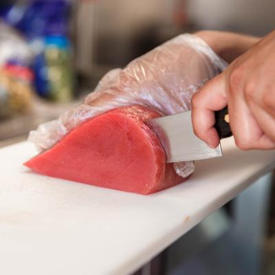 Employee cutting meat