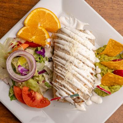 Chimichanga served with a side salad, tortilla chips and guacamole.