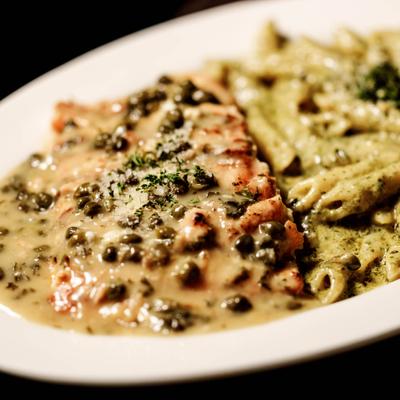 Salmon Piccata topped with sauce and capers, served with Penne Pesto.