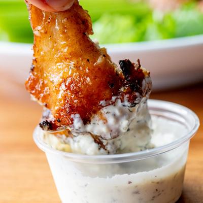 Dipping a chicken wing, close up.