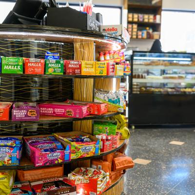 Convenience store aisle stocked with various snacks and candies.
