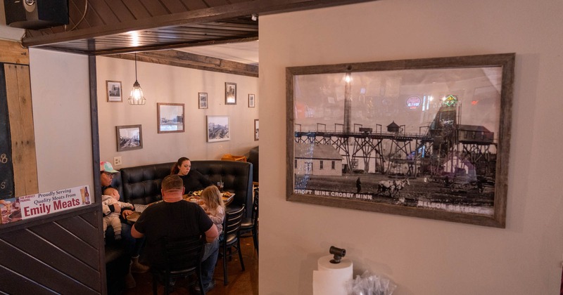 Dining room, guests in the booths, photo on the wall in front