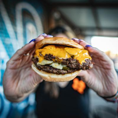 A person holding VP Burger in front of the camera.