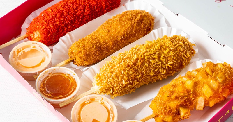 Assorted hotdogs and dipping sauces in a box