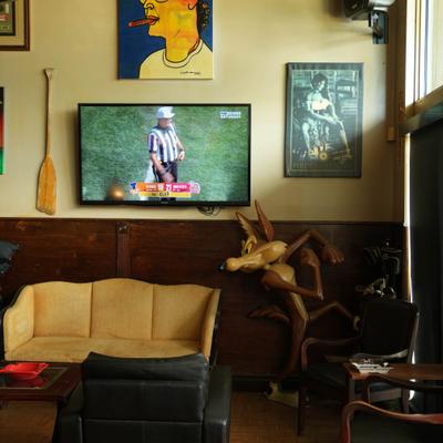 Lounge area featuring a vintage sofa, wall art, a wooden sculpture, and a TV.