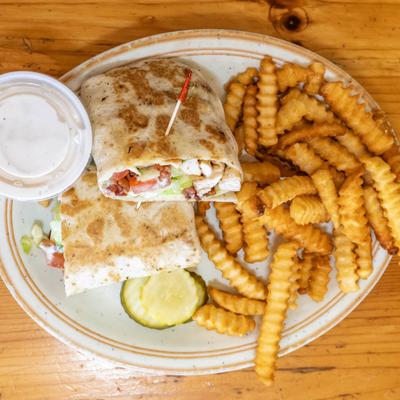 Breakfast wrap served with crinkle fries and a dipping sauce.