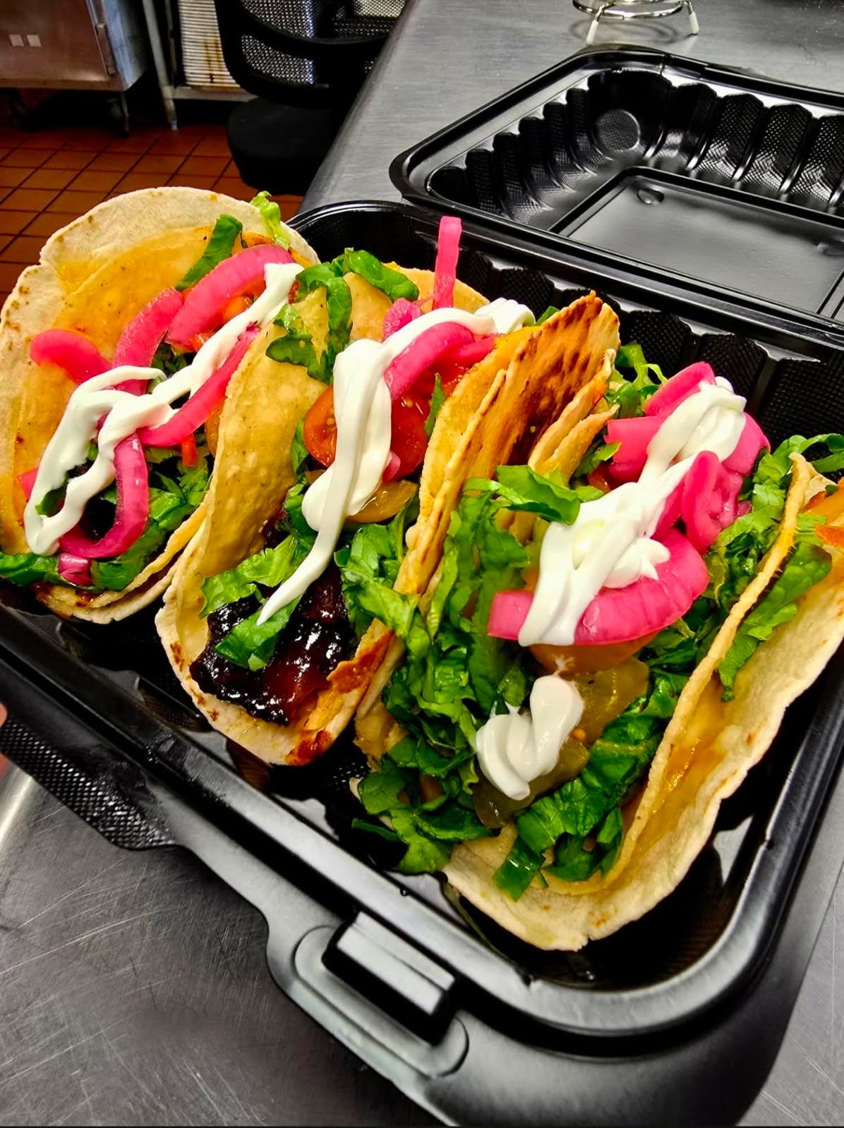 Gordita crunch taco with pickled onions, lettuce, and sour cream