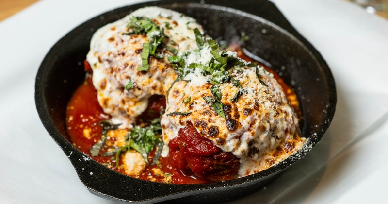 Meatballs served in a marinara sauce and topped with melted cheese