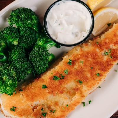 Cracker crumb-coated walleye fish with broccoli and sauce.