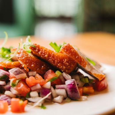 Crispy pork slices with diced vegetable garnish.