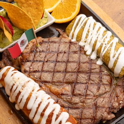 Carne Asada platter with grilled ribeye steak, two enchiladas, guacamole and chips.