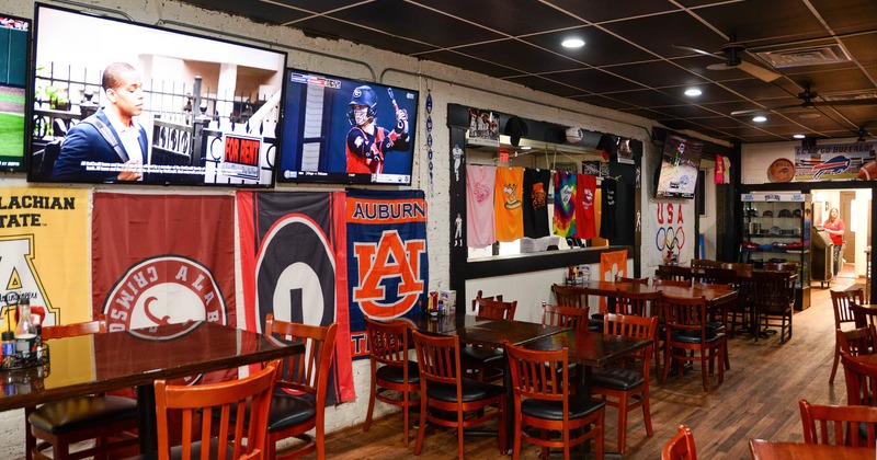 Interior, wooden tables and chairs, tv screens on the wall