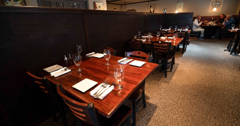 Cozy restaurant interior with wooden tables set for dining