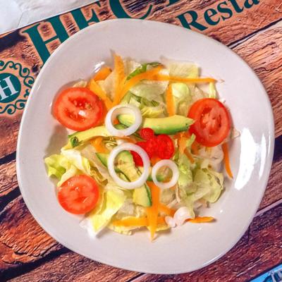House Salad with lettuce, tomato, onion, carrot and avocado.