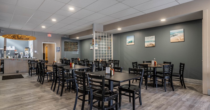 Interior seating area with chairs and tables, wall decorations