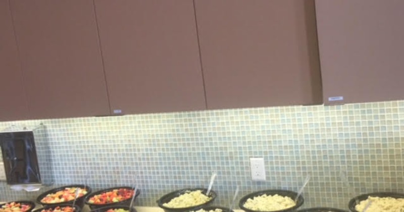Buffet setup with bowls of pasta and fruit on a counter