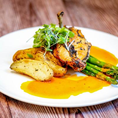 Roasted Statler Chicken served with roasted potatoes and asparagus.