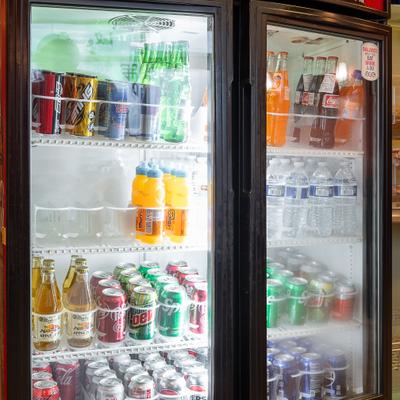 Refrigerator display filled with various canned and botteled drinks.