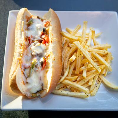 Grilled chicken sandwich, with lettuce, cheese, mayo, onion, tomato, and fries.