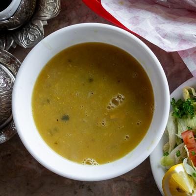 Lentil soup served alongside a salad, overhead view.