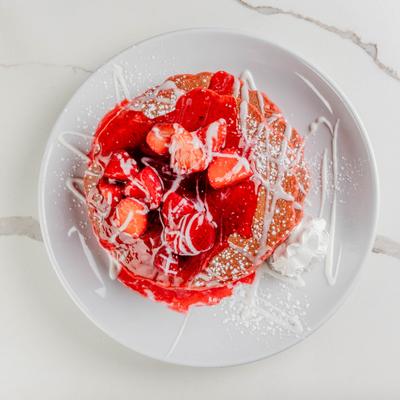Red velvet pancakes topped with strawberries.