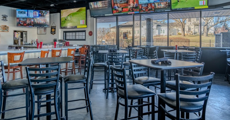 Inside, seating area with TVs on the walls