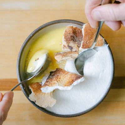 Hands holding spoons in a dessert.