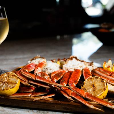 Crab legs platter served with glass of white wine.