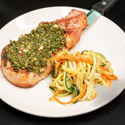 Pork chop with chimichurri sauce and salad.
