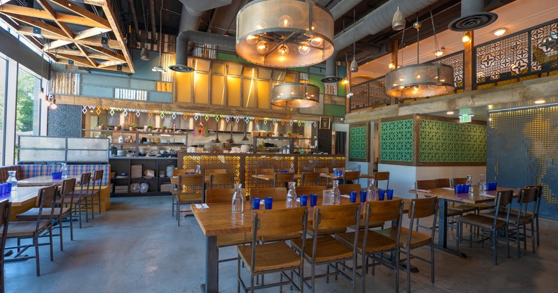 Interior, seating area, large round chandeliers hanging from the ceiling, kitchen in the back
