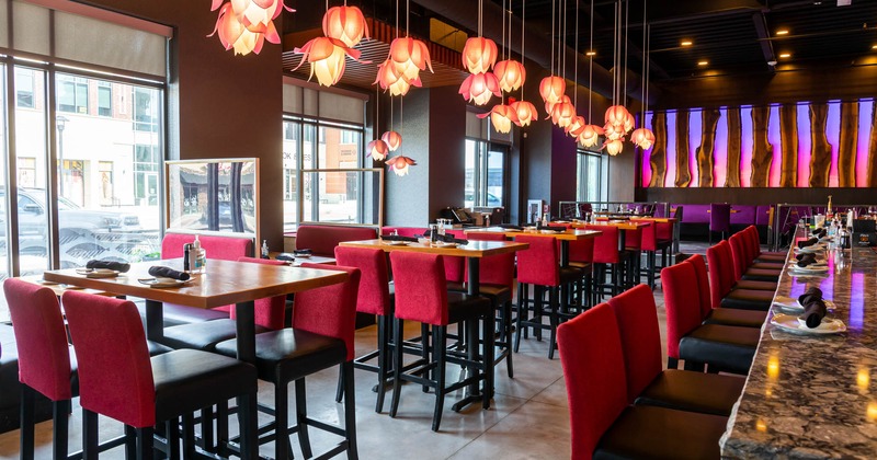 Interior, the bar counter with bar chairs, a row of dining tables and booths