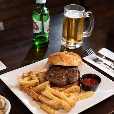Hamburger with fries and ketchup, served with beer.