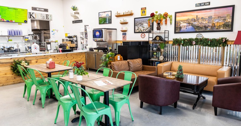 Interior with green metal chairs, wooden tables, leather couches