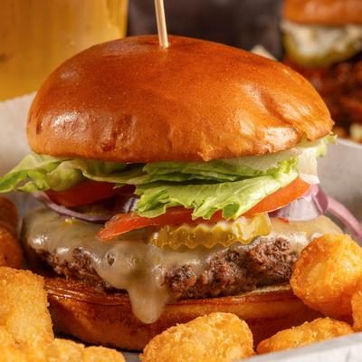 The Classic Burger with lettuce, tomato, and cheese, served with tater tots.