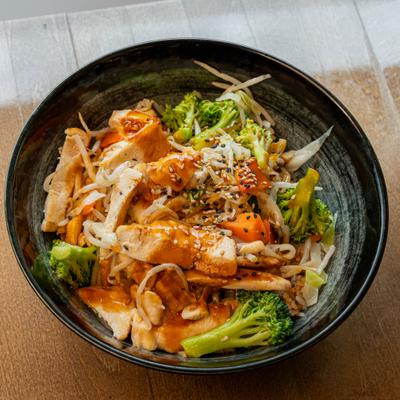 A layer of chicken teriyaki over a bowl of steamed rice.