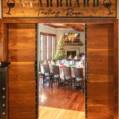 Entrance to  a dining area with a Christmas tree, fireplace, and a table set for a holiday meal.