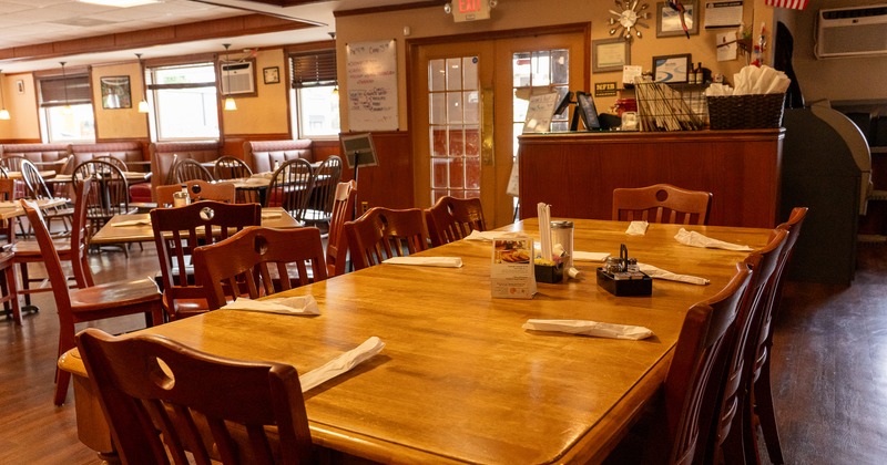 Interior of rustic dining area, a large dining table set for eight guests
