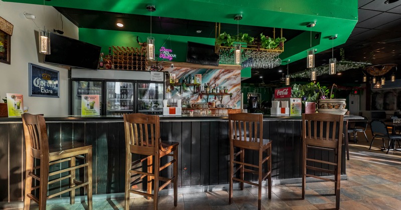 Interior, bar area, wooden top bar with wooden stools, drinks shelves in the back