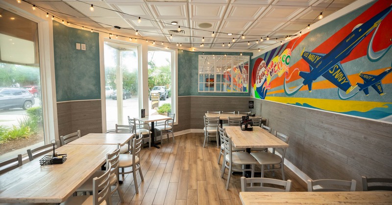 Interior featuring a colorful mural, tables, and string lights