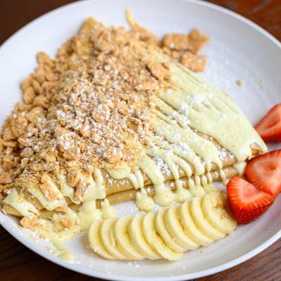 Cinnamon toast crepe with cookie bits, white chocolate drizzle, banana and strawberries.
