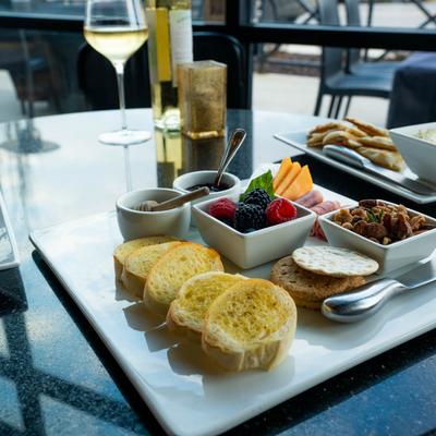 Three food plates served on table with white wine