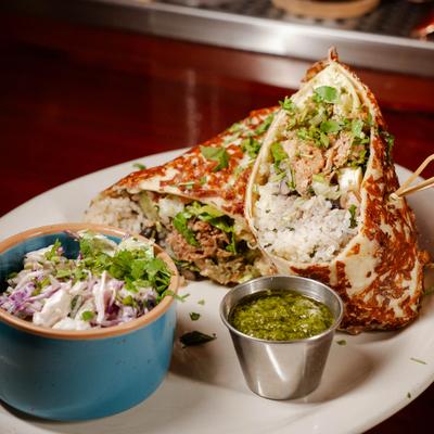 Chicken Tinga Burrito served with salsa and coleslaw.